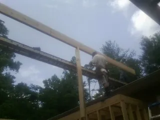 Carpenter setting a ridge beam over a new addition frame — Ice Dam Removal by Roofing Brothers in Valley Springs